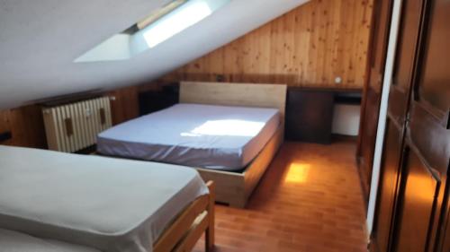 a small room with two beds and a window at Mansarda in Morgex