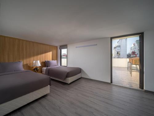 ハノイにあるMinerva Aparthotel Hanoiのベッド2台とバルコニー付きのホテルの部屋