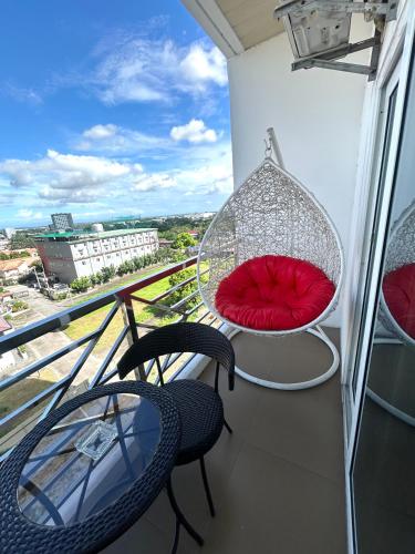 a balcony with two chairs and a red pillow at Deluxe room with king bed and Balcony at Kandi Palace in Angeles
