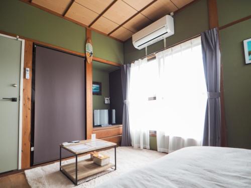 a bedroom with a bed and a window at GUEST HOUSE aoshima tei - Vacation STAY 42002v in Miyazaki