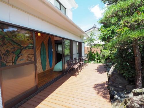 a wooden deck with chairs on the side of a house at GUEST HOUSE aoshima tei - Vacation STAY 42002v in Miyazaki