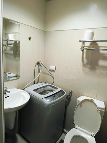 une petite salle de bain avec toilettes et lavabo dans l'établissement Shell Residences Mall of Asia by Jhem, à Manille