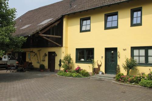 a yellow house with a green door and some flowers at Apartments Luisenhof in Krefeld