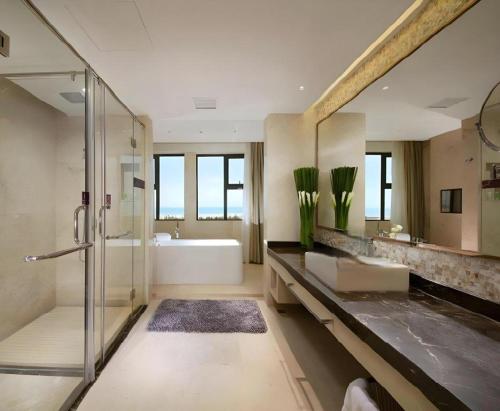 une salle de bain avec une douche, une baignoire et un lavabo dans l'établissement Fuzhou Fliport Garden Hotel, à Xianqi