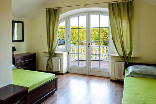 a bedroom with two beds and a sliding glass door at Pensjonat nad Strugą in Stryków