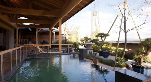 a house with a pool of water in the yard at Shiratamano Yu Kahou in Shibata