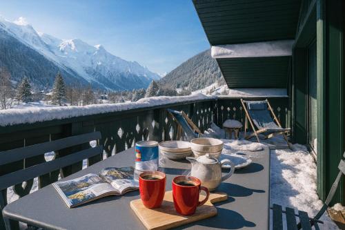 a table on a balcony with a view of mountains at Beautiful apartment with superb view of Mont Blanc in Chamonix-Mont-Blanc