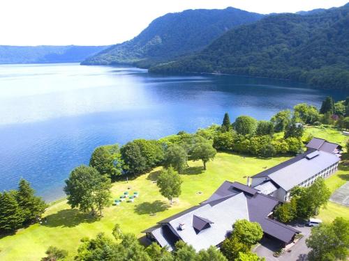 an aerial view of a house on the shore of a lake at Towada Prince Hotel in Kosaka