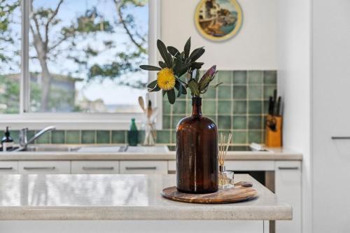 a vase with a flower on a counter in a kitchen at Point Roadknight Paradise Villa 6 - BYO Linen in Anglesea