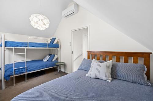 a bedroom with a bed and a bunk bed at Point Roadknight Paradise Villa 6 - BYO Linen in Anglesea