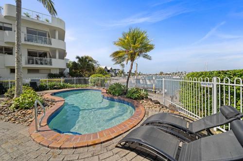 a swimming pool with a slide in front of a building at Serenity Waters Riverfront Retreat - Walk to Mooloolaba in Mooloolaba