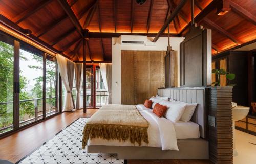 une chambre avec un lit dans une pièce avec des fenêtres dans l'établissement Villa Zolitude Resort & Spa - SHA Extra Plus, à Chalong