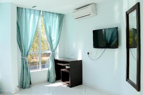 a living room with a television and a window at Hotel Darulaman Alor Setar in Alor Setar