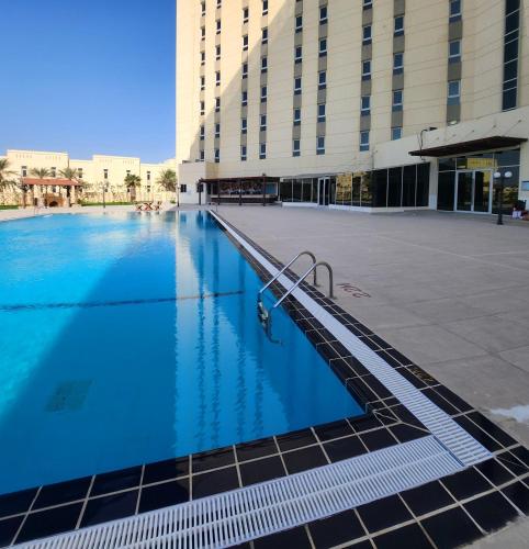 a large swimming pool in front of a building at Acacia Hotel by BP Management in Ras al Khaimah