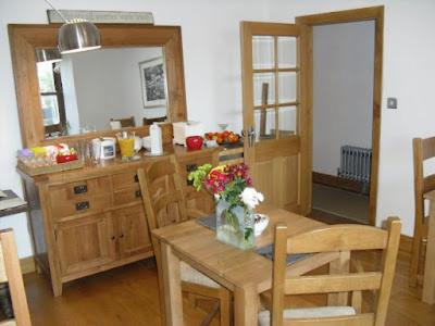 a kitchen with a table with a vase of flowers on it at Langland Road B&B in The Mumbles