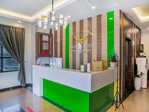a lobby with a green and white reception desk at Rajawali Homes Kota Marudu in Kampong Tumsun
