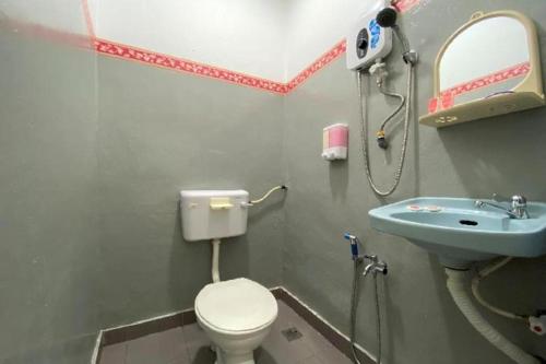 une salle de bain avec toilettes et lavabo dans l'établissement OYO 90176 D'cruz Sunrise Villa, à Pantai Kok
