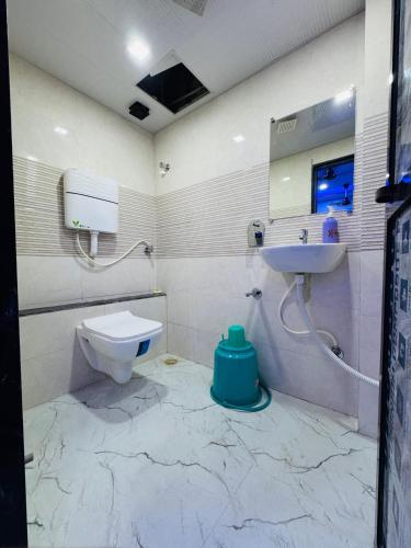 a bathroom with a toilet and a sink at Hotel Welcome Airoli in Navi Mumbai