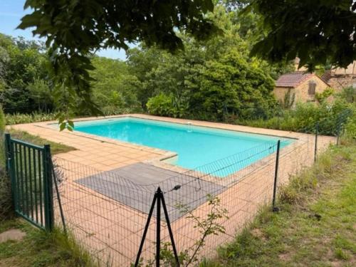 a swimming pool with a fence around it at Gîtes OSTAL de Marcillac avec piscine - Petit Bois in Capelou