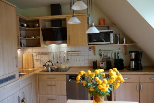 a kitchen with a vase of fruit on a table at FeWo Abendsonne in Prerow