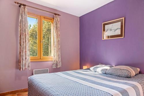 a purple bedroom with a bed and a window at La Bignone in Régusse