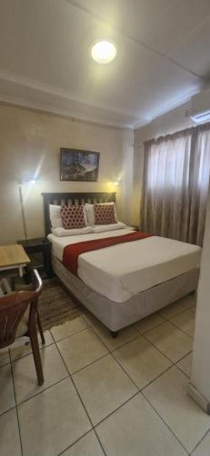a bedroom with a large bed in a room at Boiketlo Lodge Gaborone in Gaborone
