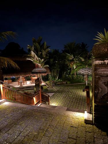 a resort courtyard at night with umbrellas at Inang Villa ubud in Ubud