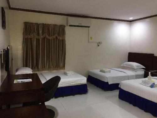 a room with two beds and a table and a desk at Jeamco Royal Hotel - Baybay in Baybay