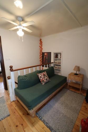 a green couch in a living room with a ceiling fan at Urbana - Ayvalık in Ayvalık