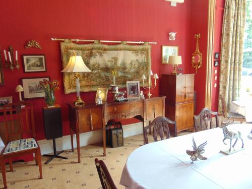 a red room with a desk and a table with chairs at Holywell House in Loughborough