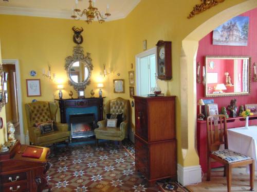 a living room with a fireplace and yellow walls at Holywell House in Loughborough