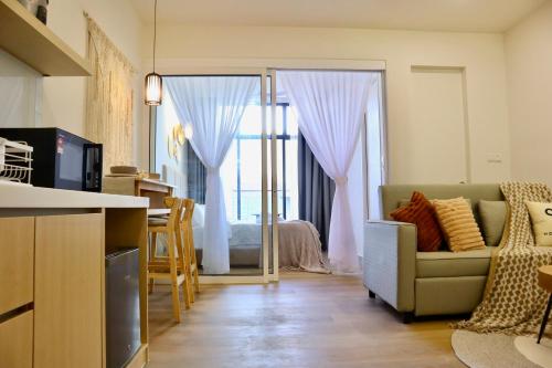 a kitchen and living room with a couch and a table at Homesuite' Home at The Shore in Kota Kinabalu