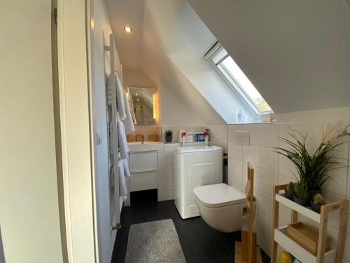 a white bathroom with a toilet and a sink at Moderne Ferienwohnung in Berlin Lichtenrade in Berlin