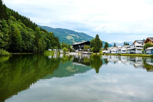 um rio com casas ao lado dele em Das Haus am Waldsee em Maishofen