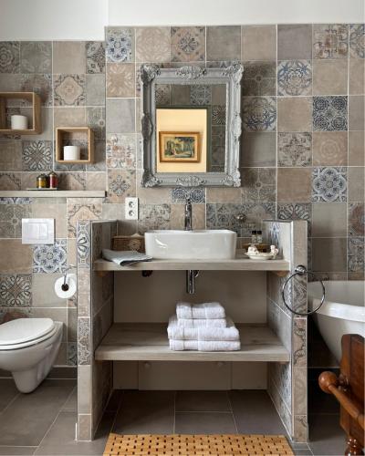 a bathroom with a sink and a toilet and a mirror at Domaine du Commandeur in Mondragon