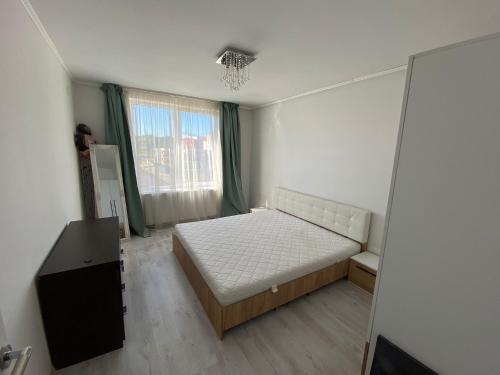 Un dormitorio pequeño con una cama y una ventana. en Apartament Tineretului Floresti, en Floreşti