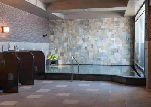 a swimming pool in a building with a glass floor at Hotel Route Inn Grand Kitami Ekimae in Kitami