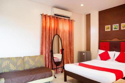 a hotel room with two beds and a mirror at OYO 153 Espacio de Clarita Hometel in Daliao