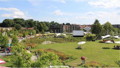 a group of people in a park with umbrellas at Komfort-Apartment - 93m2 - Zentral - Nähe Stadtpark in Pfaffenhofen an der Ilm