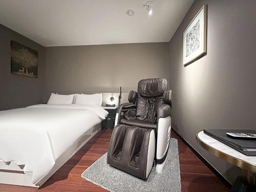 a hotel room with a bed and a chair in it at 12번길stay 