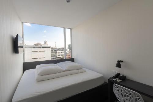 um quarto com uma cama e uma grande janela em YU! Smarthotels em Guayaquil