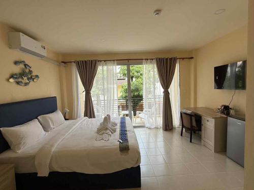 a bedroom with a bed and a desk and a television at Kata Kata Stay in Kata Beach