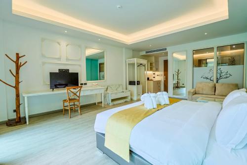 a bedroom with a large white bed and a desk at Aqua Resort Aonang Krabi in Ao Nang Beach