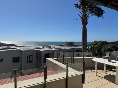 a view of the ocean from a balcony with a palm tree at Cicada 8 in Ramsgate