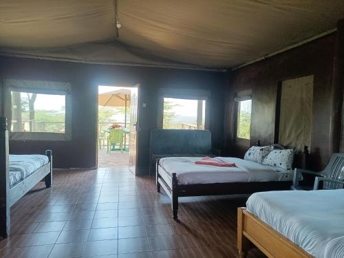 a bedroom with two beds and a room with a porch at Semadep Village Guest House in Sekenani