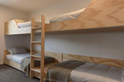 a bedroom with two bunk beds and a bed at A newly built 3 bedroom home in Methven