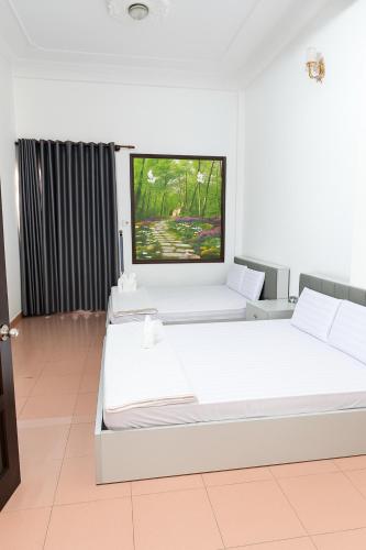 a bedroom with two beds and a flat screen tv at Ánh Sao Hotel HCM in Ho Chi Minh City