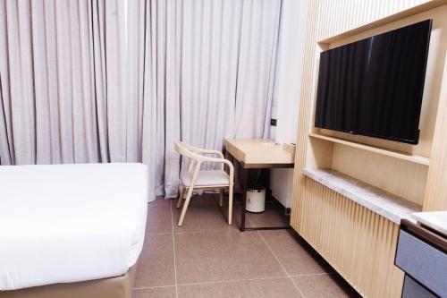 a hotel room with a tv and a table and a chair at 38 on Boulders Hotel in Gaborone