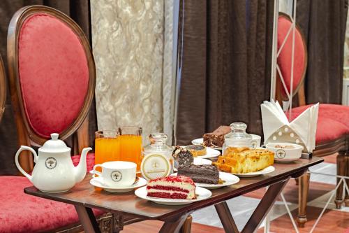 a table with a tray of pastries and orange juice at Hotel Shady Oaks in Srinagar