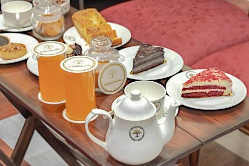 a table topped with plates of cake and drinks at Hotel Shady Oaks in Srinagar